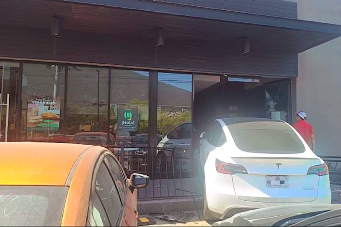 Confunde de pedal e impacta su auto eléctrico contra cafetería